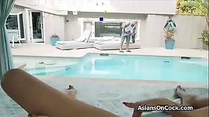 Asian bikini babe gives a handjob to a big black cock by the pool